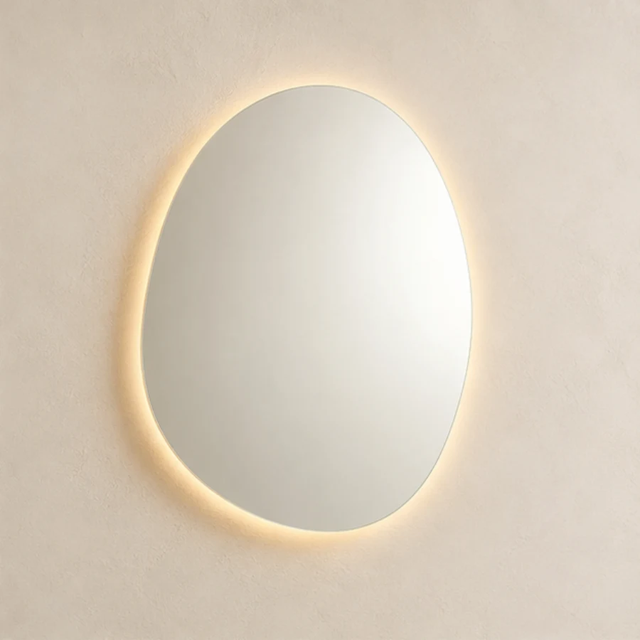 Rounded pebble shaped mirror with a warm backlit halo