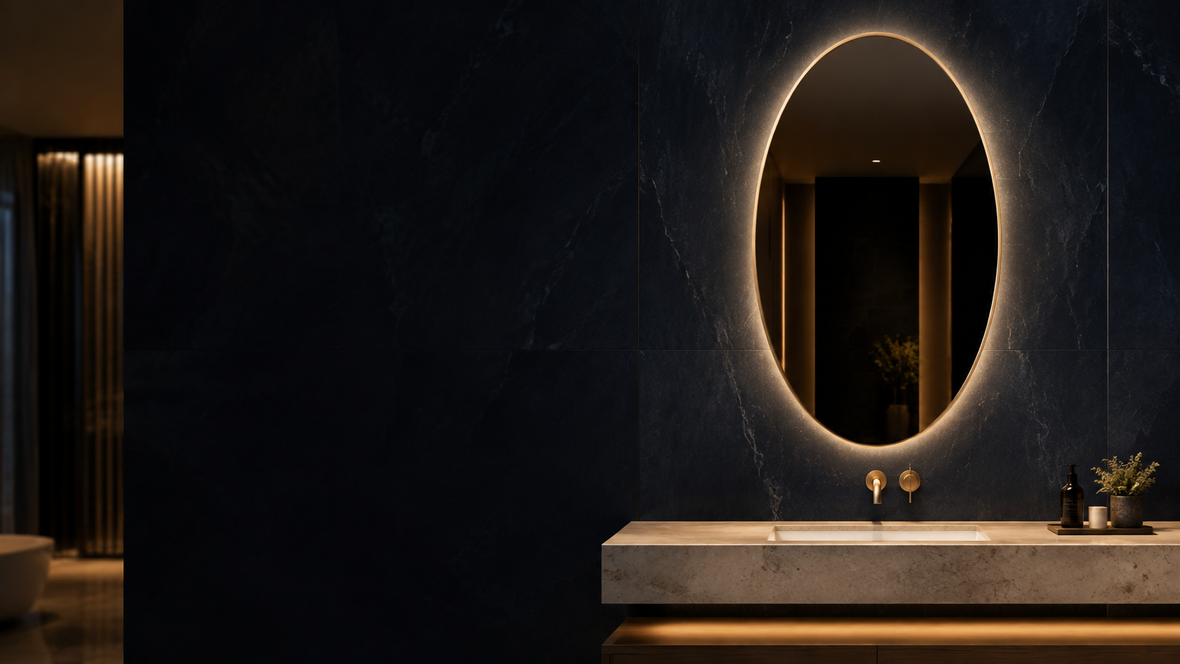 Backlit oval bathroom mirror above a hotel vanity