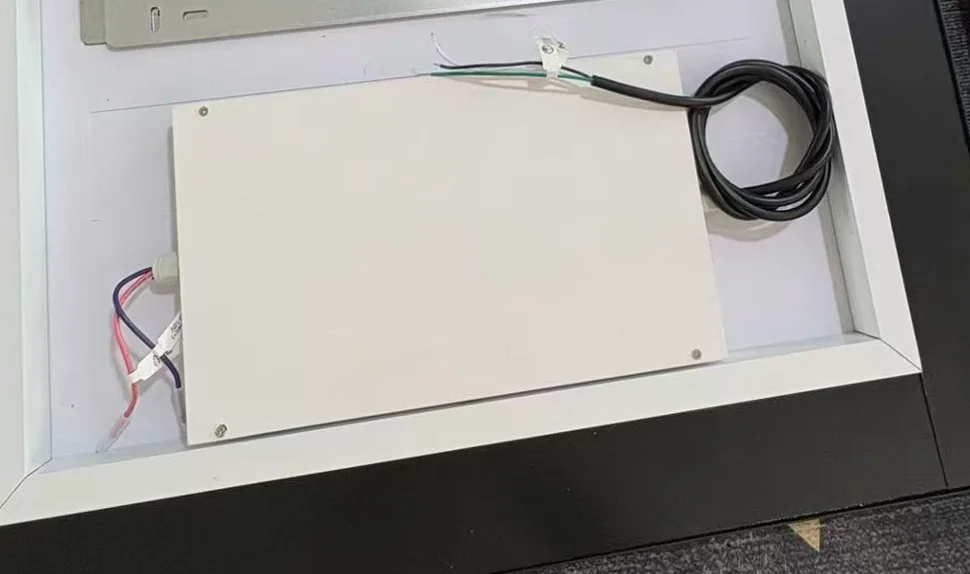Actual mirror rear assembly with a flat white metal power enclosure and cable outlets