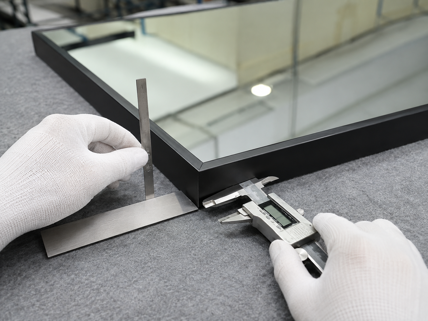 Technician checking the 90-degree corner and frame alignment of a square mirror
